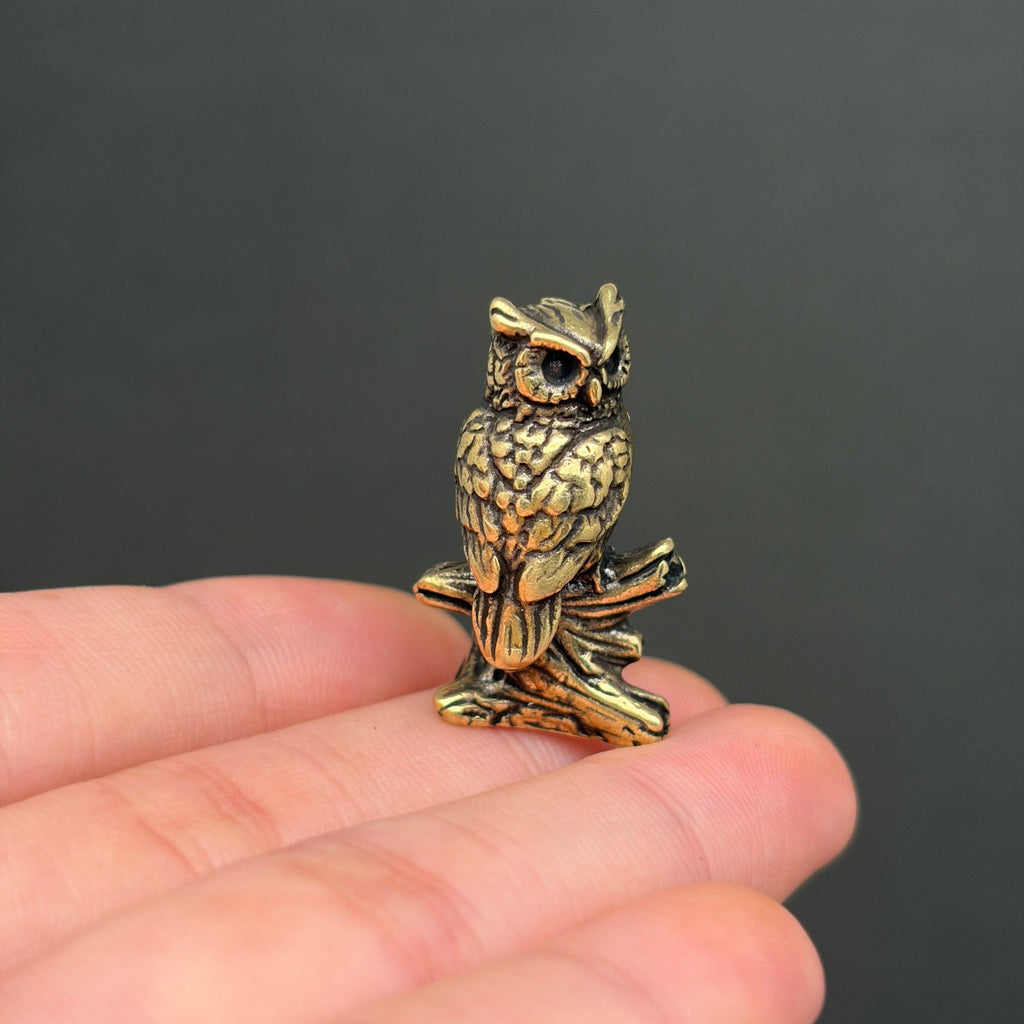 Miniature brass owl figurine on branch