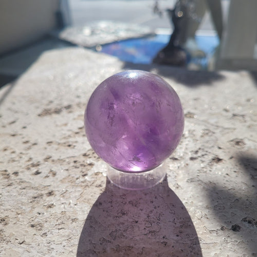 Natural 48.6mm Amethyst sphere in sunlight, exact specimen view 1