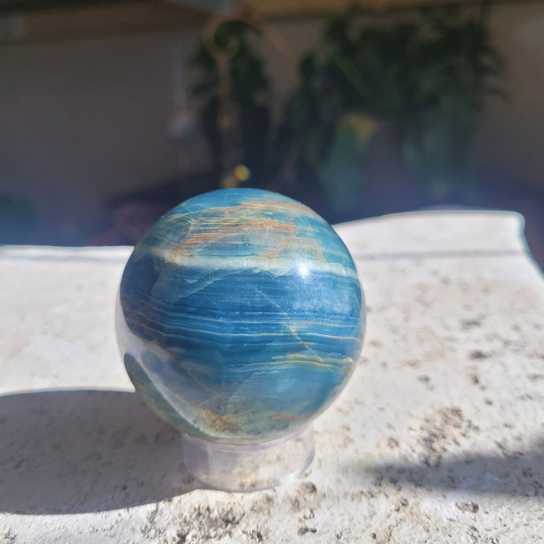 Blue Onyx sphere showing deep blue layered banding and creamy white stripe