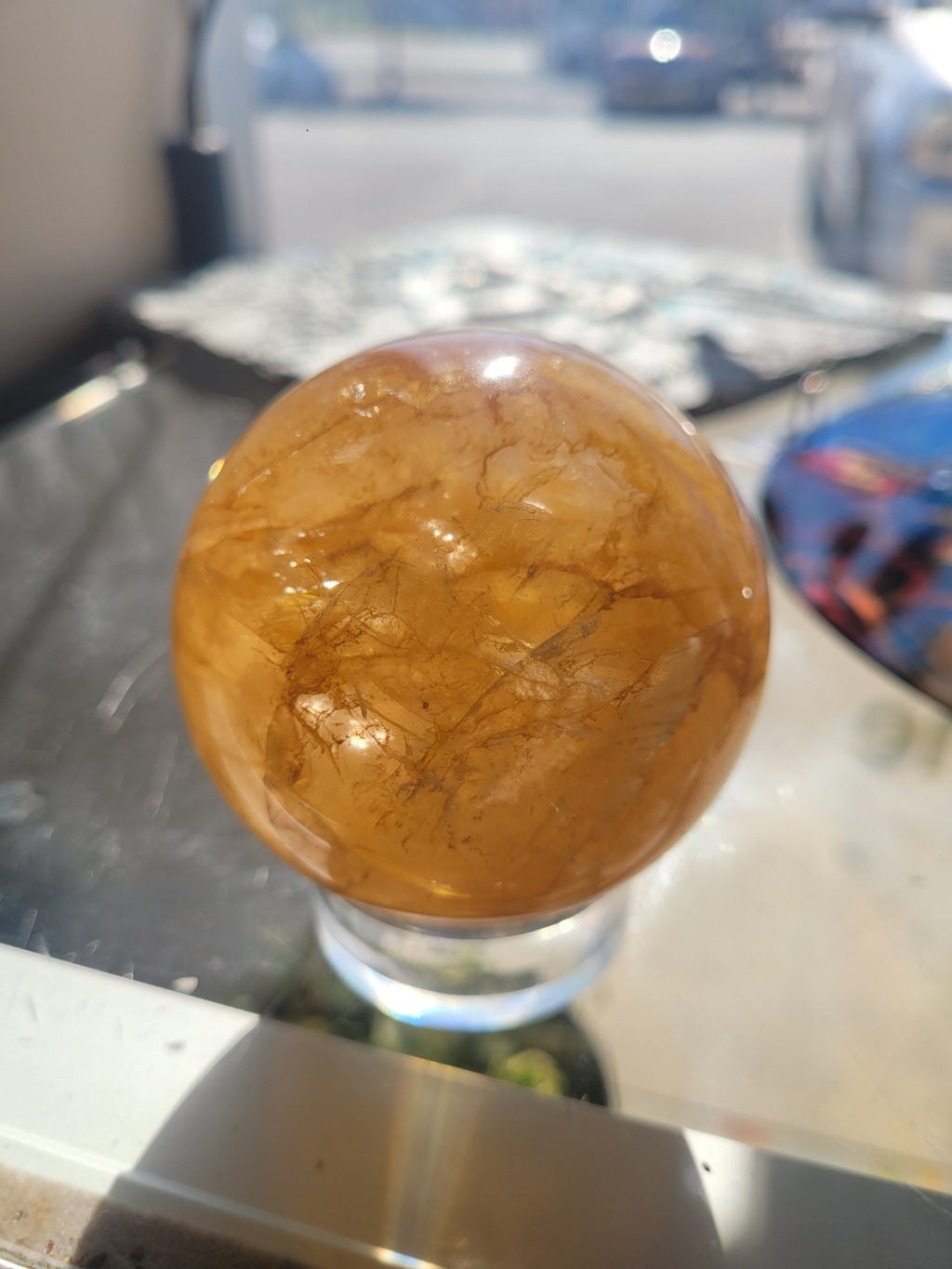 Golden Healer Quartz sphere showing darker iron-colored veining and natural internal landscape